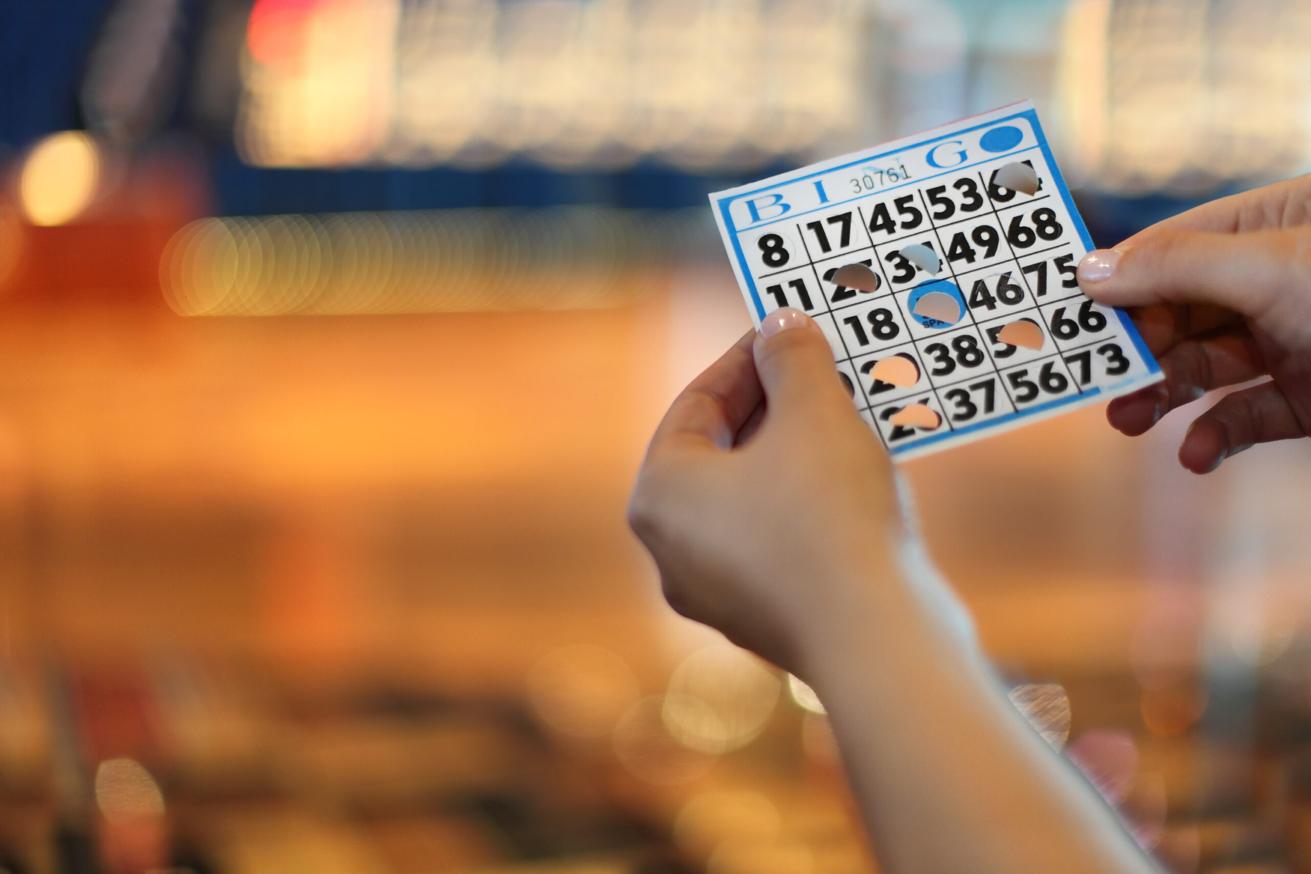 Woman hands hold bingo card with holes