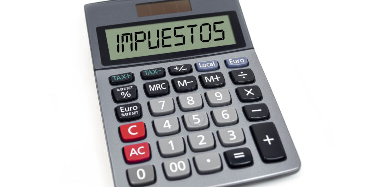 Calculator with the spanish word for tax - impuestos isolated
